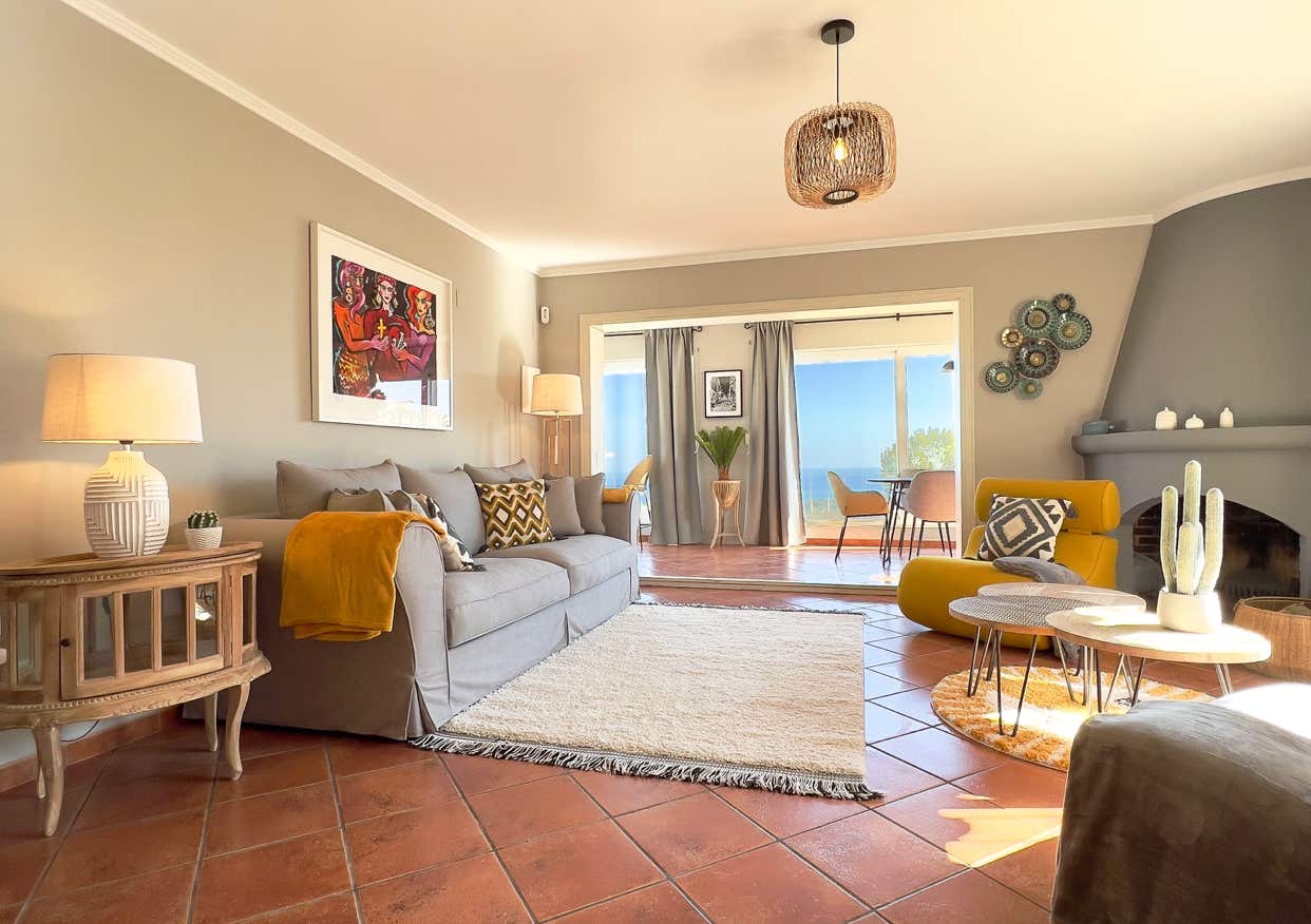 Helles Wohnzimmer mit Meerblick, gemütlichem Sofa und stilvollen Dekoelementen