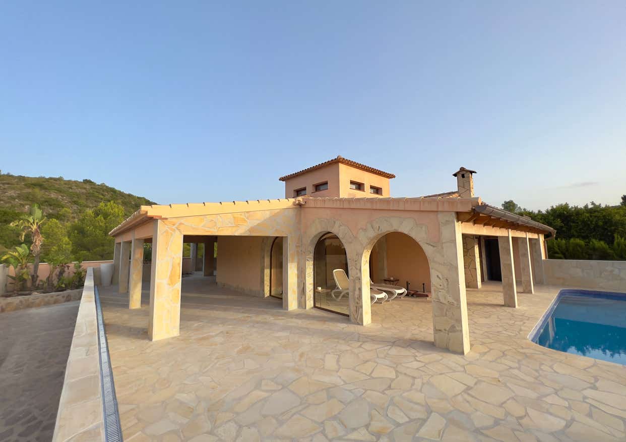 Großzügige überdachte Terrasse mit Rundbogenarkaden und Natursteinboden