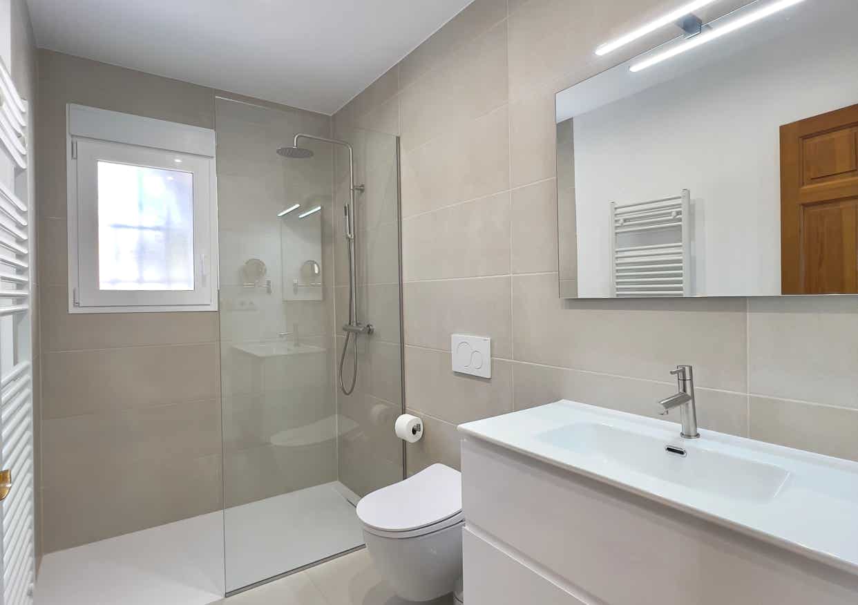 Modernes Bad mit großer Glasdusche, Wand-WC und Spiegelbeleuchtung
