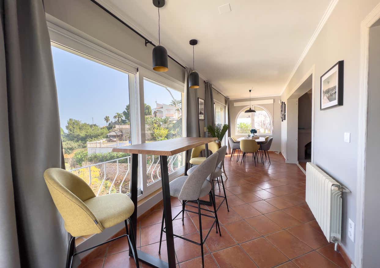 Lichtdurchfluteter Wohnbereich mit Bartisch und Blick ins Grüne - modernes Interior Design