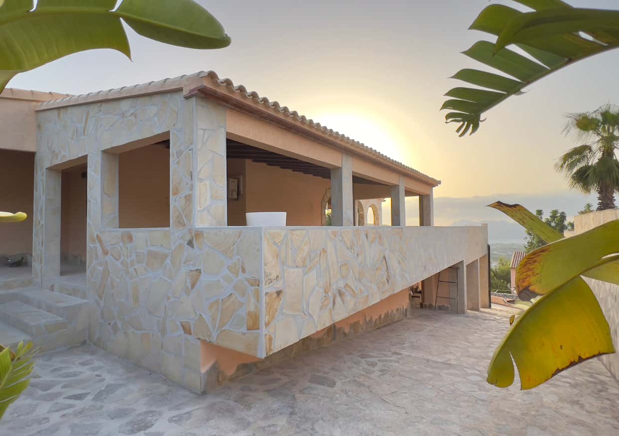 Detailansicht einer Natursteinmauer mit integrierter Terrasse in mediterranem Stil