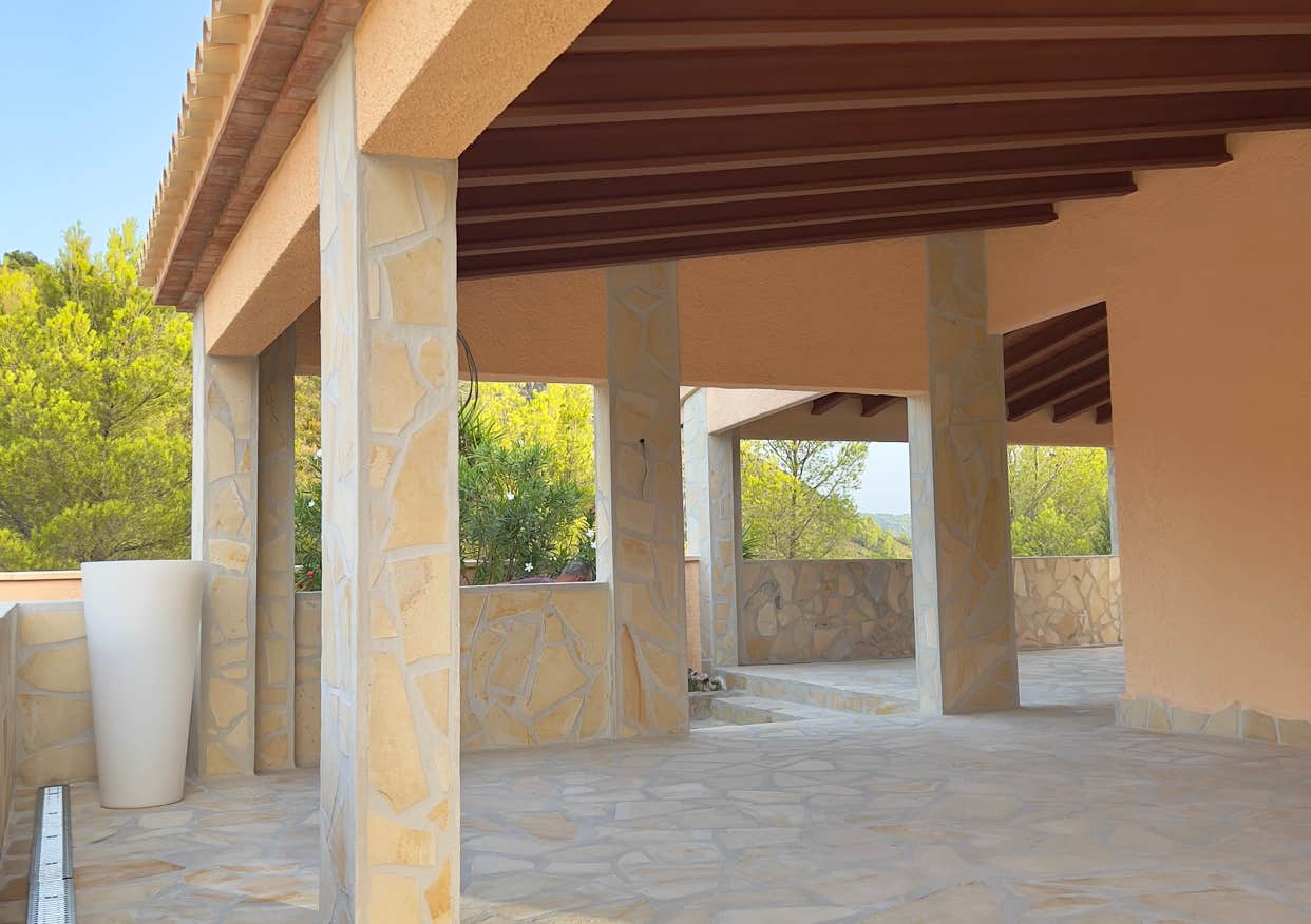 Überdachte Loggia mit massiven Säulen und weitem Blick ins Grüne
