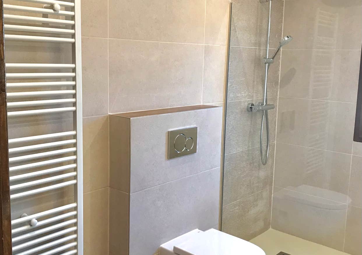 Badezimmer mit begehbarer Dusche, wandhängendem WC und Designheizkörper